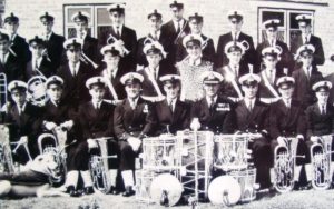 HMS COLLINGWOOD BAND ME WITH DOG. JOHN MARSHALL 6 ALONG BACK. JOHN TUCKER MIDDLE ROW 4 FROM END. BARRY WEST BOTTOM ROW 3 FROM RIGHT.